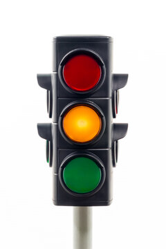 Close-up view of a traffic light showing an illuminated amber light.  Concept image illustrating change and control of the COVID 19 pandemic.

