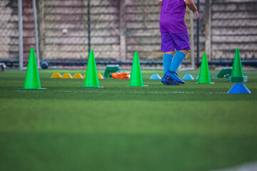 Obraz premium Soccer ball tactics on grass field with cone for training in background Training children