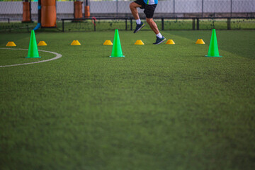 Soccer ball tactics on grass field with cone for training in background Training children