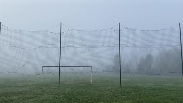 stade de foot avec une ambiance terrifiante, qui fait peur, par temps froid avec du brouillard 