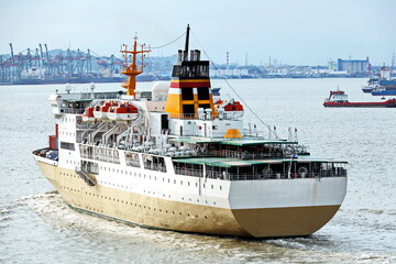 Vessels, passenger ships and tugboats in port under cargo operations and underway. Port of Surabaya, Indonesia, January,2021