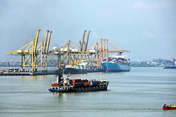 Naklejka premium Vessels, passenger ships and tugboats in port under cargo operations and underway. Port of Surabaya, Indonesia, January,2021