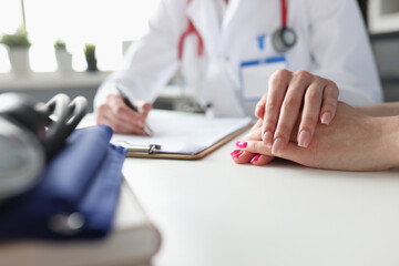 Female doctor holding the patient's hand, close-up