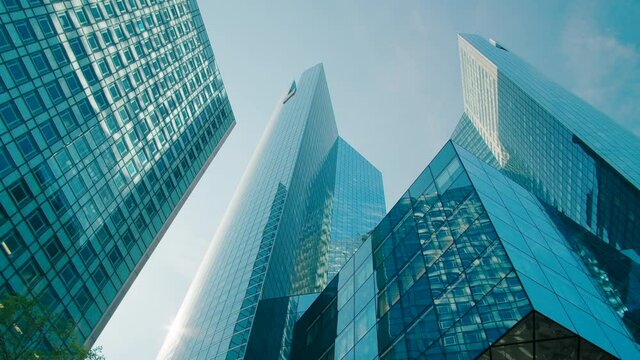 Modern Futuristic Architecture with Blue Glass Skyscrapers and Office Buildings in Paris Downtown, France. Business District with Corporate Skyline and Geometric Perspective. 4K Wide b-roll shot
