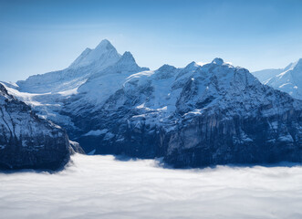 Mountains peaks and clouds in the valley. Natural landscape. Mountain range through the clouds. Landscape in the summertime. Large resolution photo.