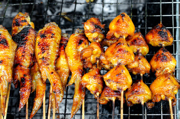 Grilled chicken wing and bud in wooden stick. Thai traditional style street food or appetizer cooking