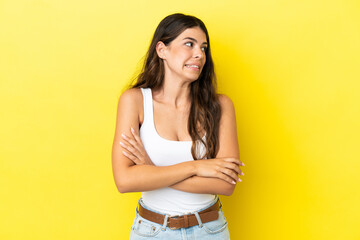 Young caucasian woman isolated on yellow background making doubts gesture while lifting the shoulders