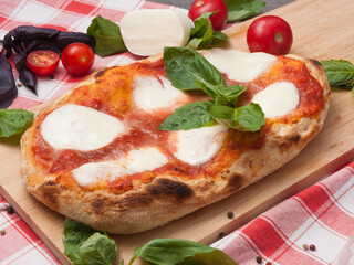pizza margarita on Roman dough on a wooden board