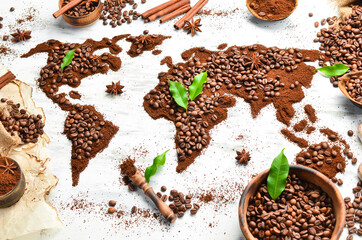 World map. Fragrant coffee beans on a white wooden background. Traditional drinks. Top view.