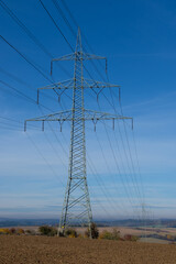 Stromversorgung: Eine Überlandleitung führt Strom über die Felder - Strommast /...