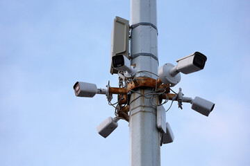 Outdoor surveillance video cameras on a concrete pole in blue sky. Cctv camera, concept for security, privacy and protection from crime