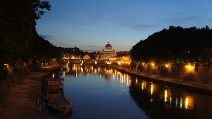 River embankment in Rome, reflection of lights in the water, bridge over the river in Rome