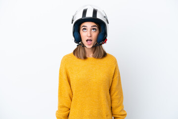 Young caucasian woman with a motorcycle helmet isolated on white background looking up and with surprised expression