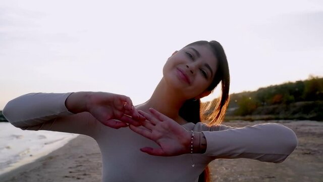 rejoicing and smiling young girl on the beach, sunset time.