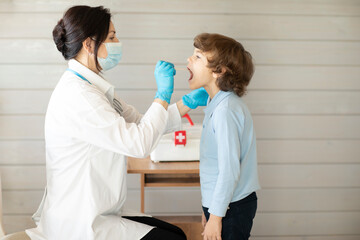 the doctor looks at the boy's throat, examination of the patient