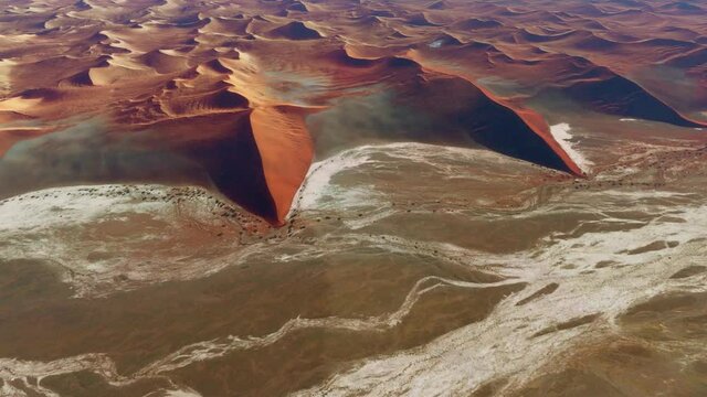 Aerial view of Sossusvlei sometimes written Sossus Vlei is a salt and clay pan surrounded by crips red dunes located in the southern part of the Namib Desert 4k high quality resolution animation