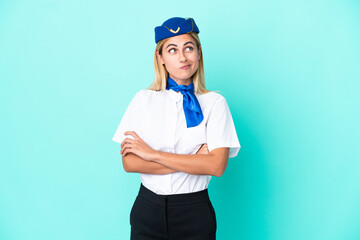 Airplane stewardess Uruguayan woman isolated on blue background making doubts gesture while lifting...