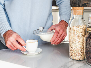 Handsome man preparing a healthy breakfast. Close-up, indoors. Day light, studio photo. Concept of healthy and delicious food