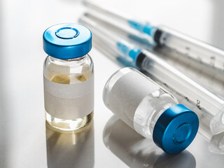 Syringes, injection bottles and tablets lying on the table. Close-up, indoors, view from above. Day light, studio photo. Healthcare concept