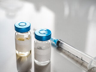 Syringes, injection bottles and tablets lying on the table. Close-up, indoors, view from above. Day light, studio photo. Healthcare concept