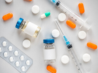 Syringes, injection bottles and tablets lying on the table. Close-up, indoors, view from above. Day light, studio photo. Healthcare concept