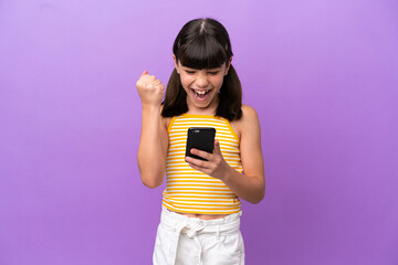 Little caucasian kid isolated on purple background surprised and sending a message