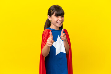 Little super hero kid isolated on purple background pointing to the front and smiling