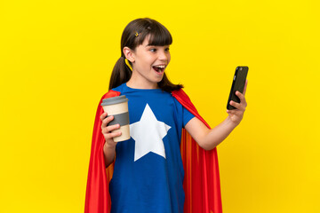 Little super hero kid isolated on purple background holding coffee to take away and a mobile