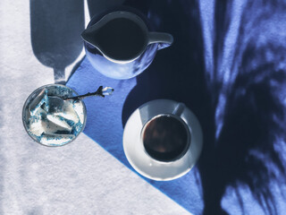 Coffee in a white cup with a spoon with ice-cream on a blue and white background 