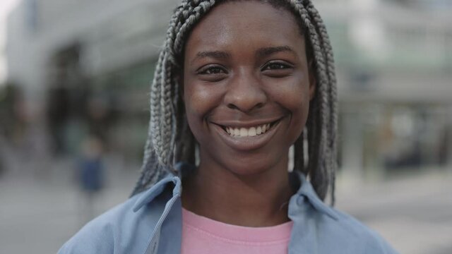African american woman with dreadlocks smiling on street