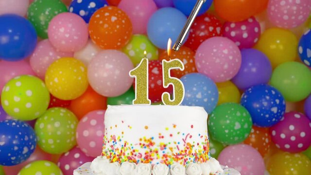 Birthday cake with candles number 15. Cake on a bright festive background of colorful balloons.