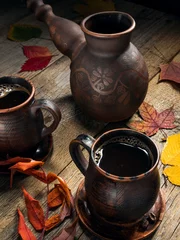 Foto op Aluminium A pair of ceramic cups with hot and aromatic coffee brewed in a ceramic turk, surrounded by autumn leaves on a wooden table. © Денис Чернышев