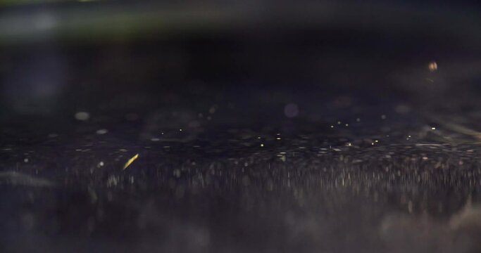 Yellow drop falling on surface of oil closeup 4k movie