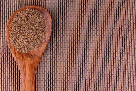 Dill seeds in a wooden spoon. Copy space.