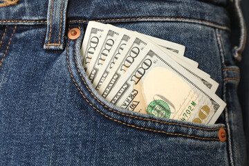 Dollar banknotes in pocket of jeans, closeup. Spending money