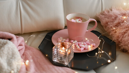 Romantic composition of a Cup of hot coffee pink on a light beige sofa