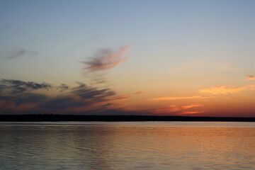 Naklejka na ściany i meble Sunset on Lake Ladoga, blue sky, clouds, forest on the distant shore - view from the ship