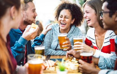 Multiracial friends drinking beer at brewery pub garden - Genuine friendship life style concept with guys and girls enjoying happy hour food together at open air bar dehor - Warm vivid filter - 469082540