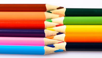 a simple image.  colored pencils lie side by side on a light background