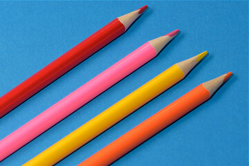 a simple image. four simple colored pencils on a blue background