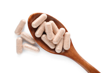 Gelatin capsules in spoon on white background, top view