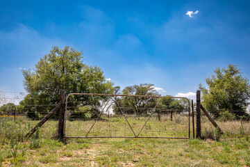 Old farm gate and fence in the middle of a grassland