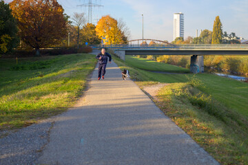 Man racing his Border Collie along a footpath beside a river
