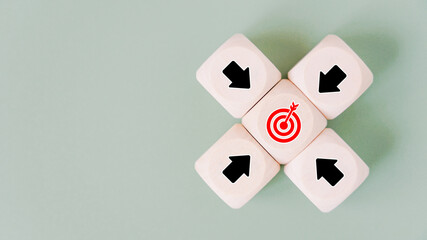 black arrow icons on wooden block around red dartboard for brainstorming, goal or target concept, with copy space