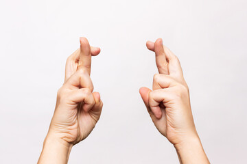 Female hands crossing fingers for good luck isolated on a white background. Waiting for the results