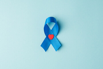 Top view photo of blue ribbon and small red heart symbol of prostate cancer awareness on isolated...