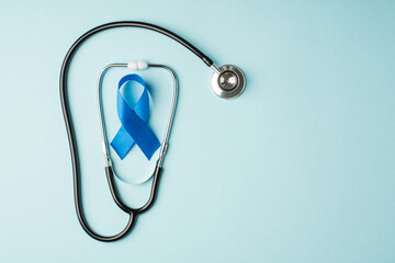 Top view photo of stethoscope and blue silk ribbon symbol of prostate cancer awareness on isolated...