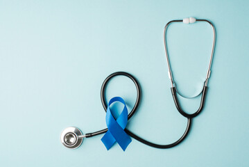 Top view photo of stethoscope and blue silk ribbon symbol of prostate cancer awareness on isolated...