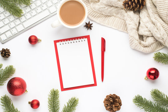 Top view photo of notebook pen keyboard cup of hot drinking red christmas tree balls pine twigs cones anise and cozy sweater on isolated white background with blank space