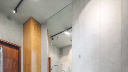 Fototapeta na wymiar Modern interior of bathroom. Grey and wooden design. Ceiling with lamp